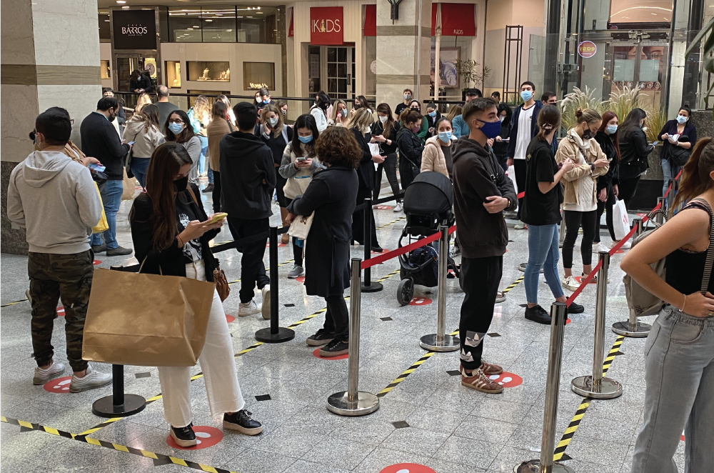 fila de personas esperando comprar ropa. fast fashion. consumismo